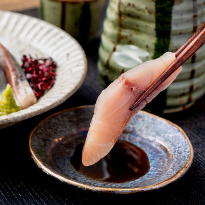 北海道寿都産活〆フクラギの刺身を醤油につける,ふくらぎの刺身と日本酒