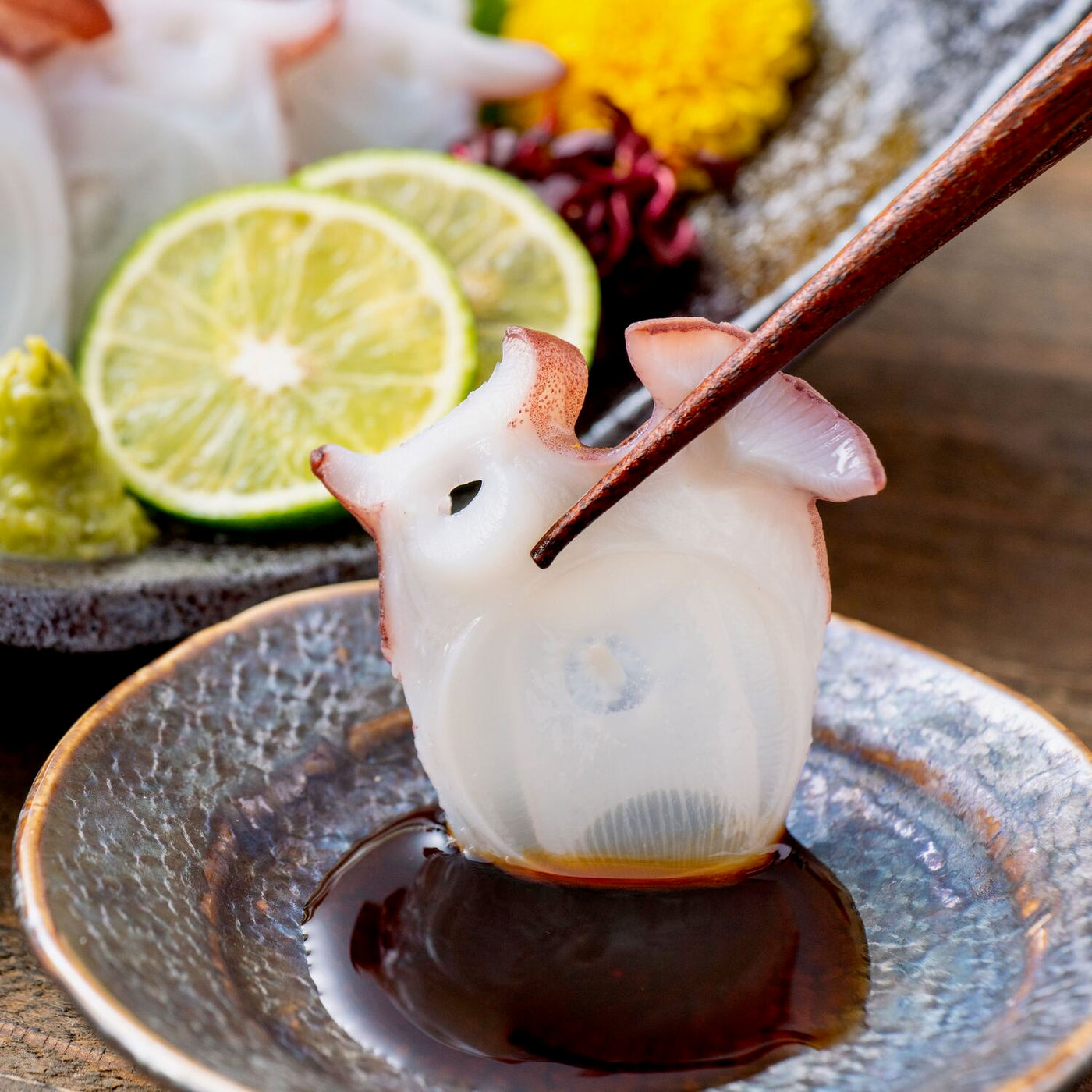 北海道寿都産活〆茹でタコの刺身,ミズタコの刺身を醤油につける