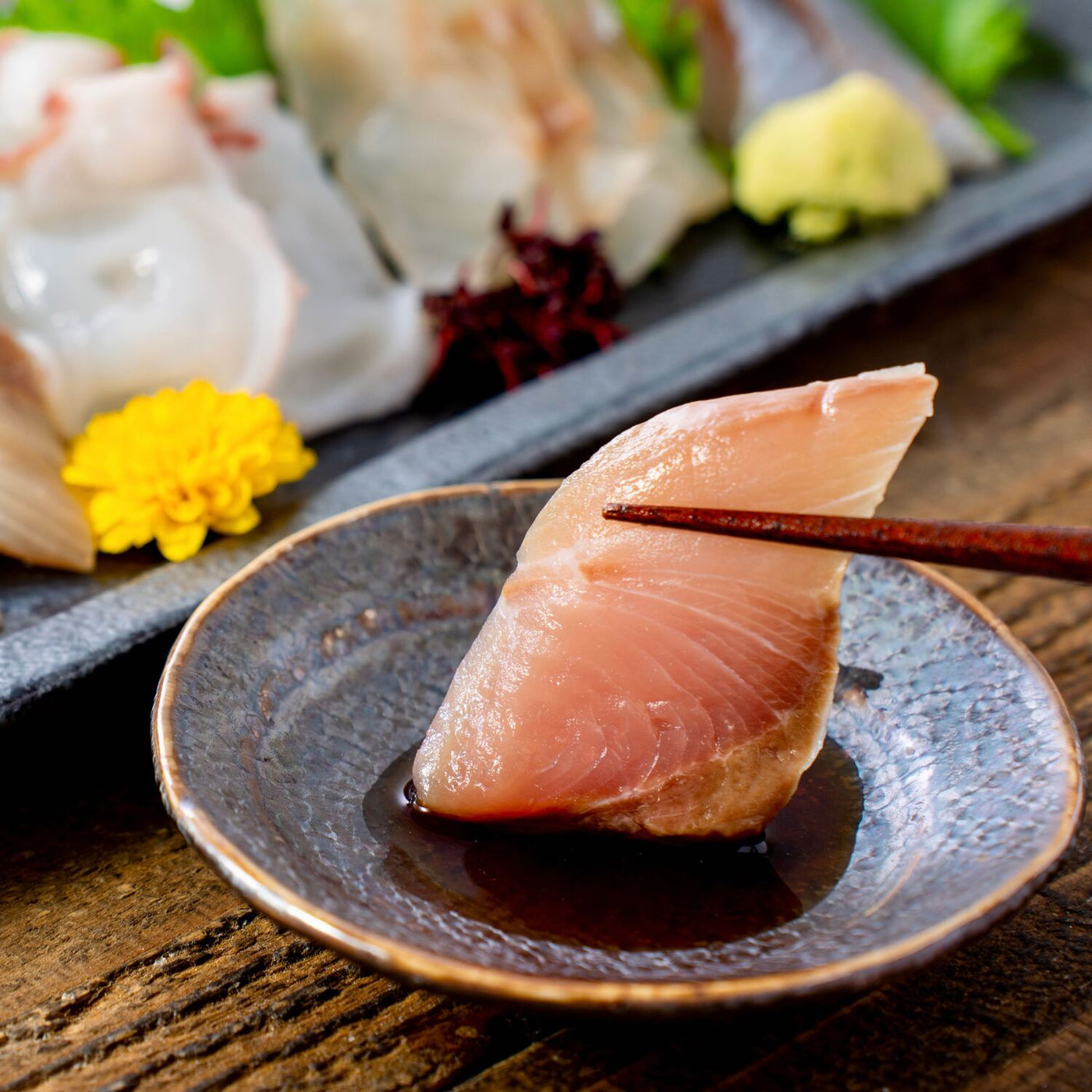 北海道産の新鮮な刺身を醤油に浸す,マルホン小西漁業の活〆3D凍結の刺身